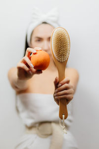 Close-up of woman holding apple against white background