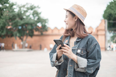 Young woman using mobile phone in city