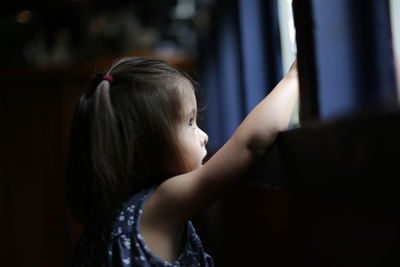 Thoughtful girl looking through window