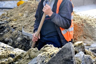 Midsection of worker holding equipment