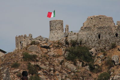 Low angle view of castle on mountain against sky