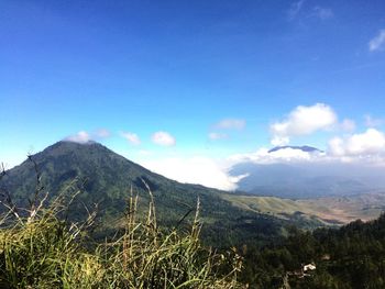 Scenic view of mountains against blue sky