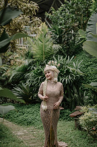 Rear view of woman standing against plants