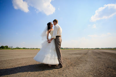 Couple kissing against sky