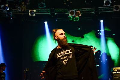 Full length of man standing against illuminated lighting equipment