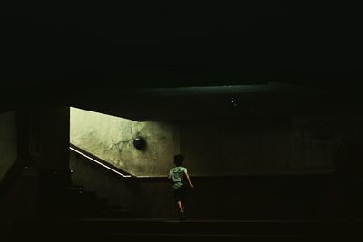 Rear view of man walking in subway tunnel