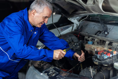 Mechanic repairing an old car