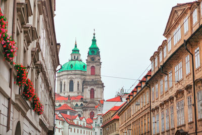 Church of saint nicholas, baroque church in prague lesser town, towers over a narrow street 