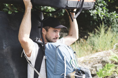 Portrait of a rock climber carrying crashpad and backpacks