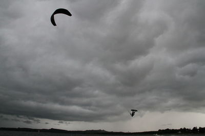 Low angle view of man paragliding against sky