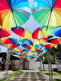 Low angle view of multi colored umbrellas hanging on footpath