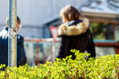 Rear view of woman standing by plants