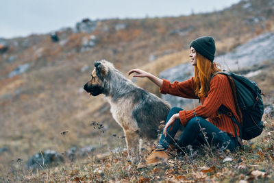 Side view of dog sitting on land