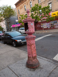 Fire hydrant on street in city against sky