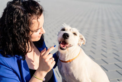 Close-up of young woman playing with dog