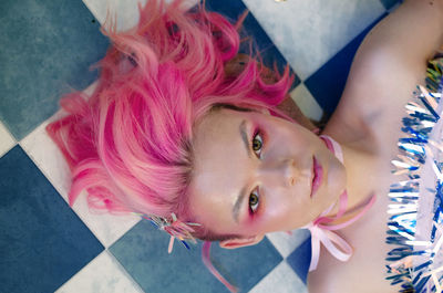 High angle view portrait of woman lying on tiled floor