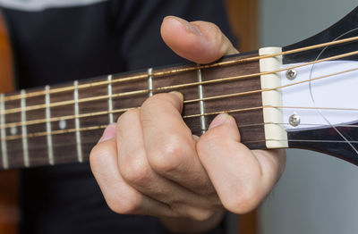 Midsection of person playing guitar