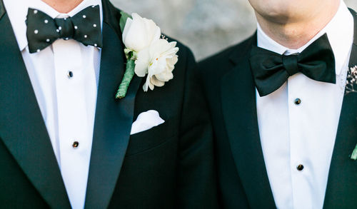 Midsection of man standing by white flowers