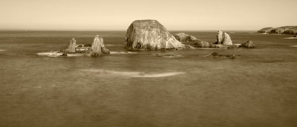 Panoramic view of rocks on shore against sky