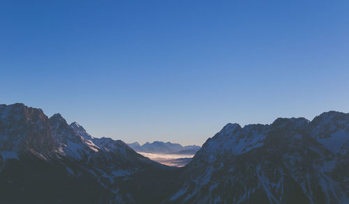 Scenic view of mountains against clear blue sky