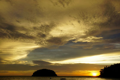 Scenic view of sea against dramatic sky during sunset