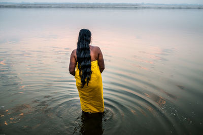 Rear view of woman standing on beach