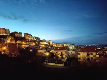 High angle view of illuminated buildings against sky at night