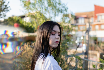 Young woman with eyes closed standing outdoors