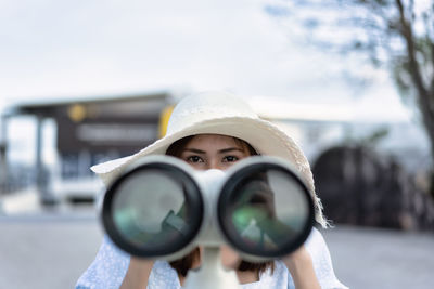 Portrait of young woman holding hat