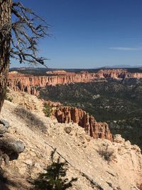 Rock formations on landscape against blue sky