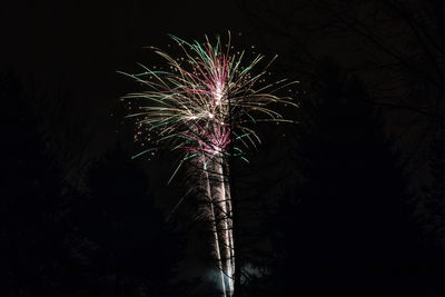 Low angle view of firework display at night