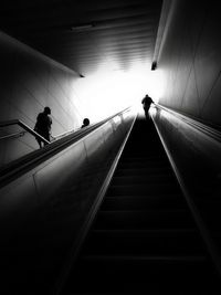 Low angle view of silhouette people walking on staircase