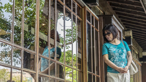 Full length of a girl standing against window