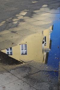 High angle view of building by puddle on street