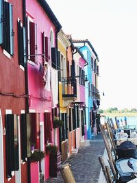 Multi colored houses in row against buildings in city