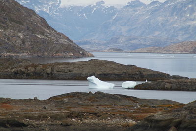 Scenic view of icy lake and snowy mountains