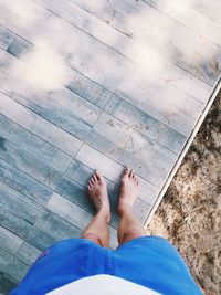 Low section of man standing by swimming pool