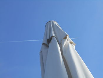 Low angle view of textile against blue sky