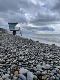 Pebbles on beach against sky