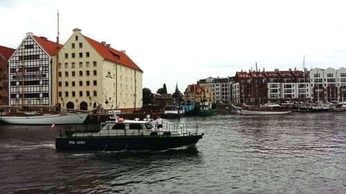 Boats in canal with buildings in background