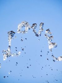 Close-up of splashing water against blue sky