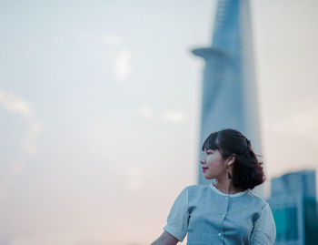 Young woman against tower in city