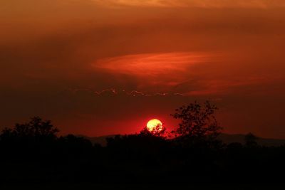 Scenic view of silhouette trees against romantic sky at sunset