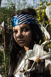 Close-up portrait of young woman standing at park