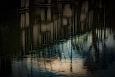 Reflection of silhouette trees in calm lake