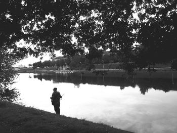 Man standing by lake against sky