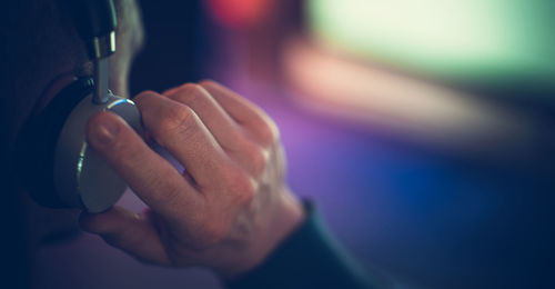 Cropped hand of man holding dentures