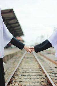 Cropped image of man holding umbrella against sky