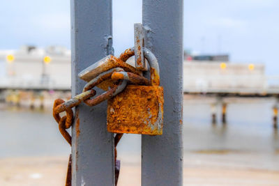Close-up of padlocks on metal chain against sky