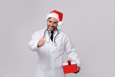 Portrait of smiling young man in hat against white background